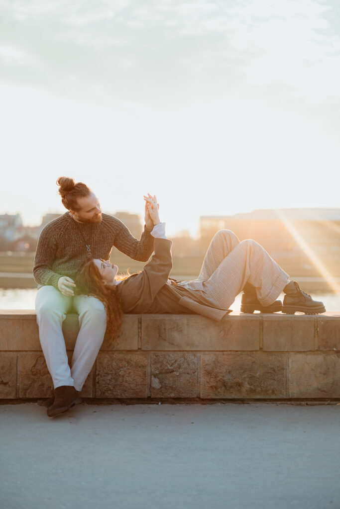Para leży na murku, sesja miejska dla pary, Kraków, Kazimierz